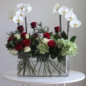 White Phalaenopsis orchids, red roses, white roses, and green hydrangeas in a glass vase by Elandra flowers, best flower shop in Dubai