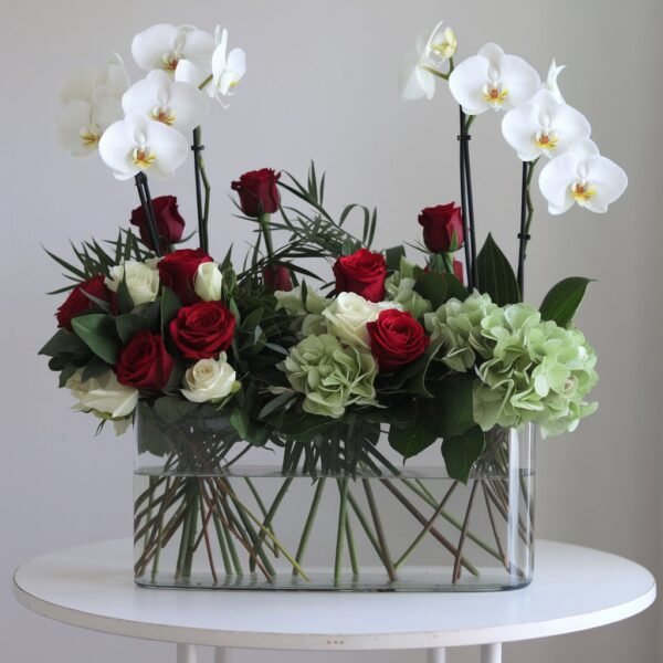 White Phalaenopsis orchids, red roses, white roses, and green hydrangeas in a glass vase by Elandra flowers, best flower shop in Dubai